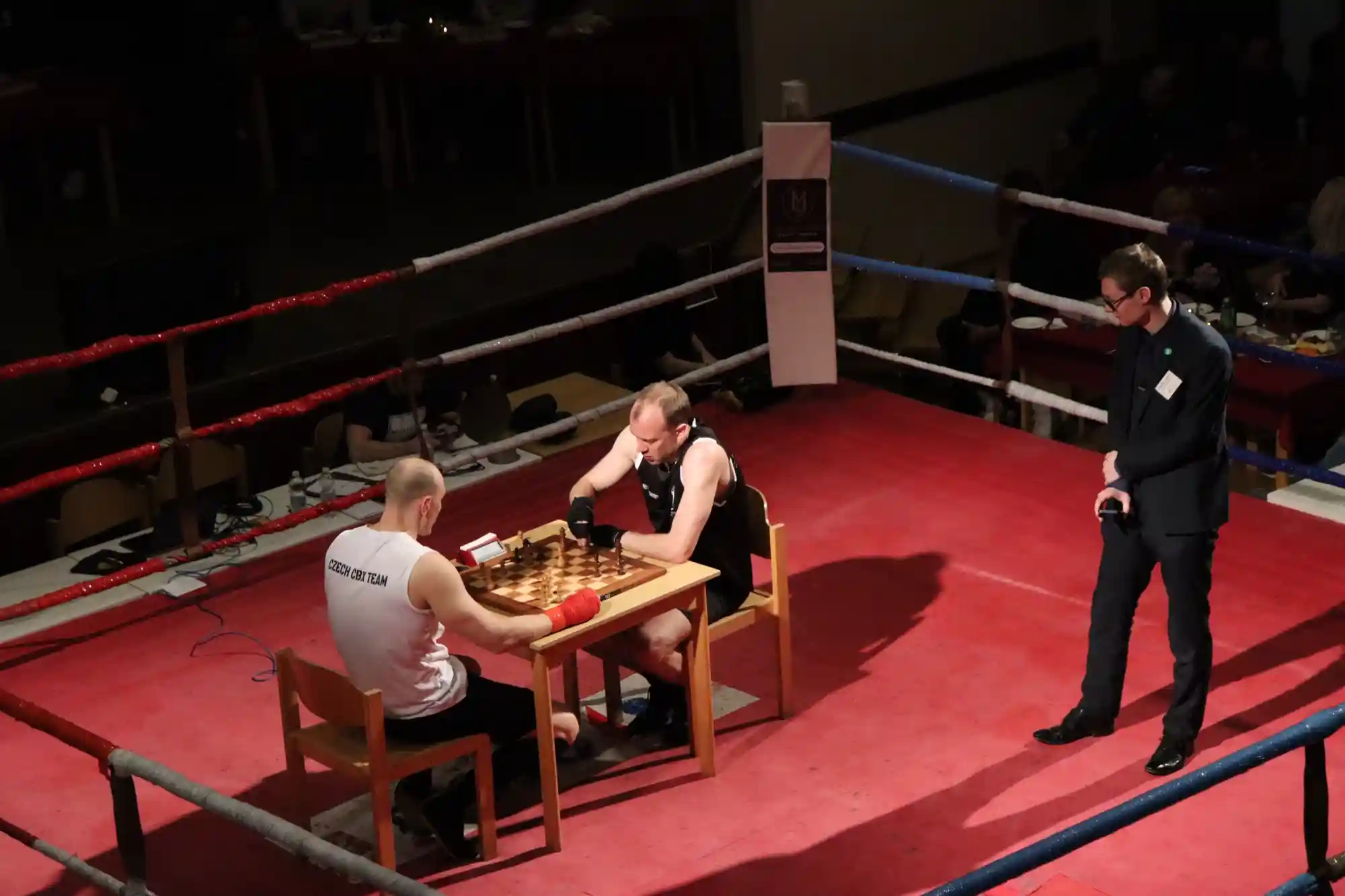 Chessboxing na CBX 1 v Kralupech: zápasníci u šachovnice v ringu